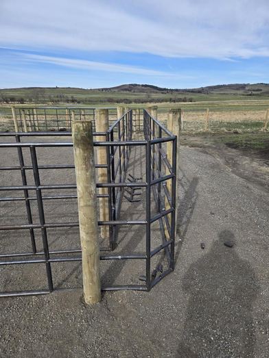 Curved Ranchcore panel section meeting at a wooden corner post with Alberta foothills in the background