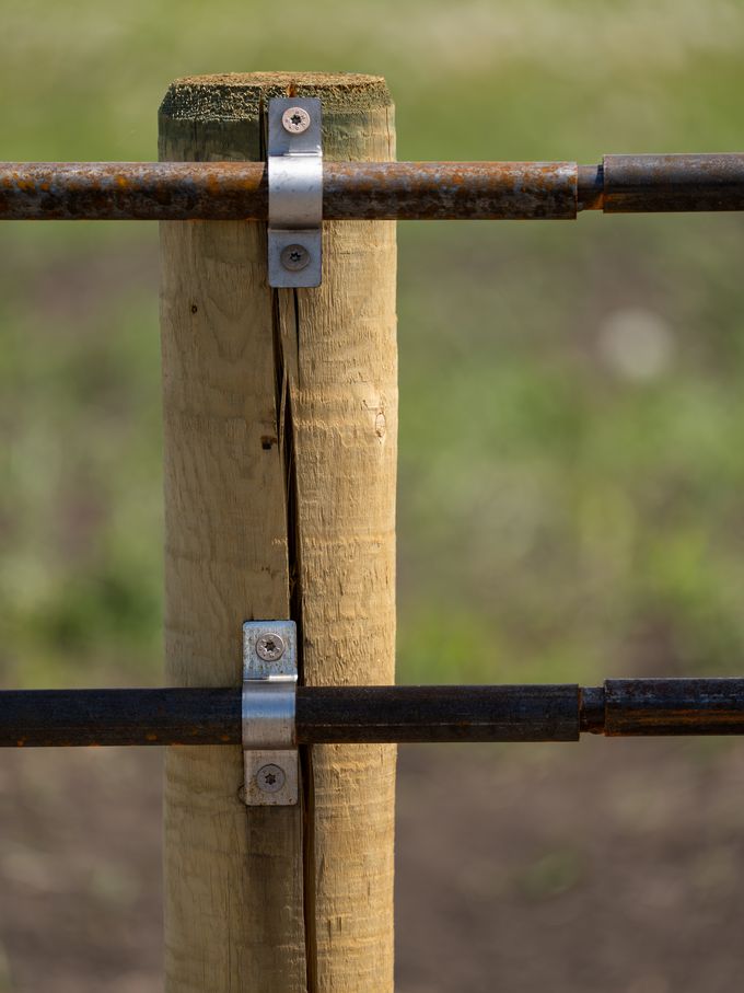 Mounting U-brackets bolting Ranchcore panel rails to a wooden post